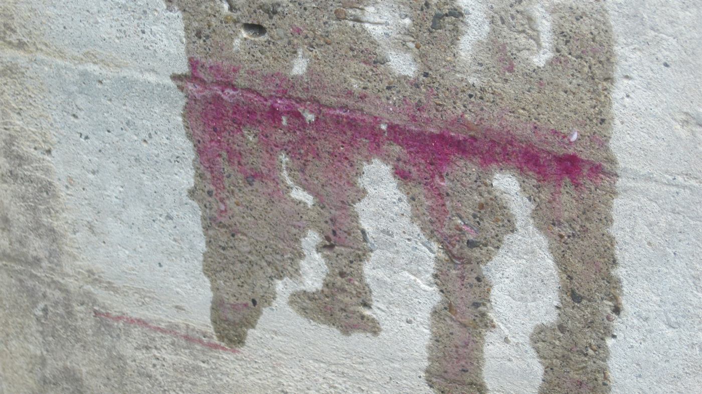 Ensayo con fenolftaleína sobre muro de concreto mostrando el frente de carbonatación
