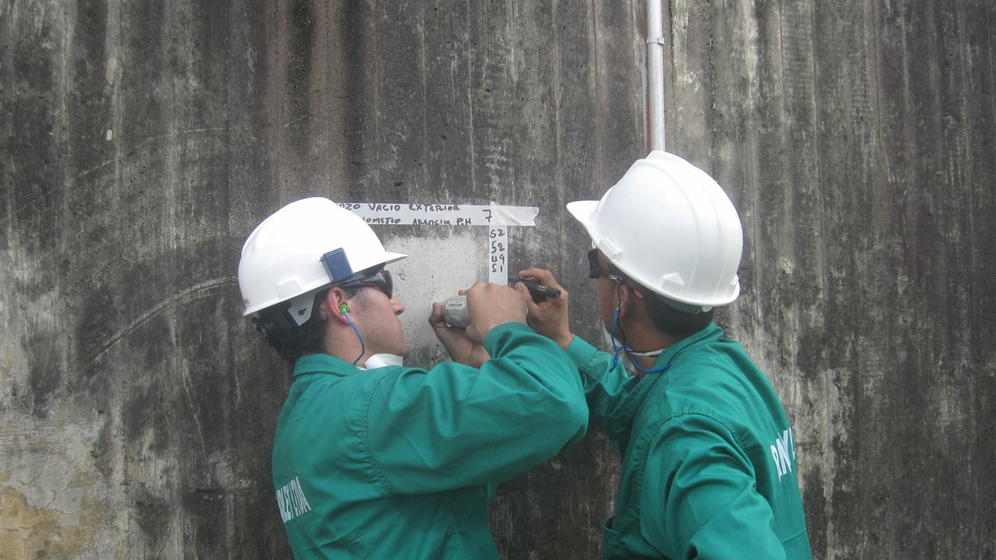 Equipo de ingenieros tomando mediciones en campo sobre un muro